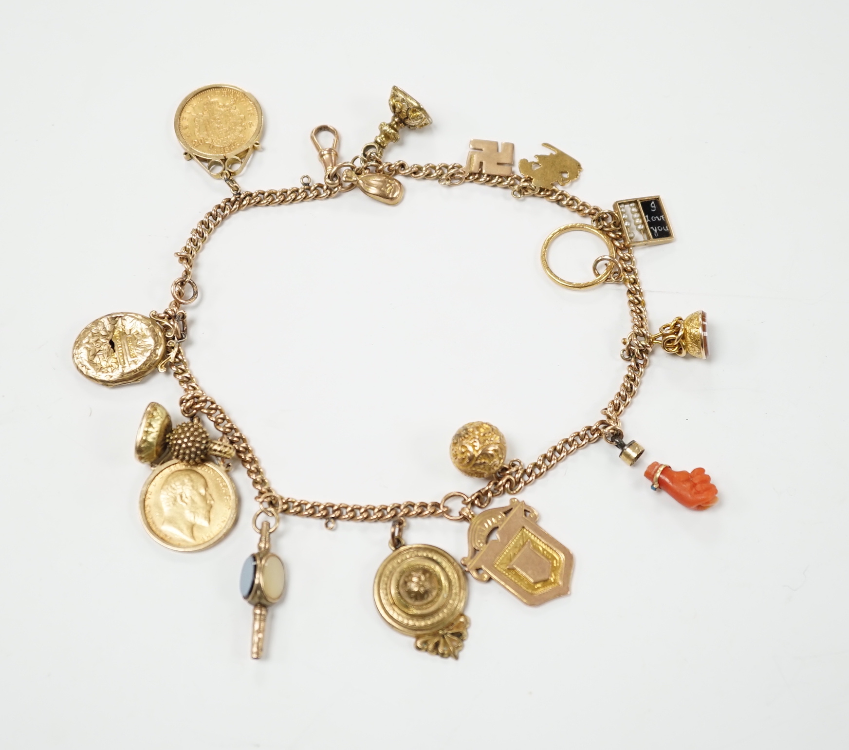 A 9ct gold curblink chain hung with fifteen assorted charms including a 1906 sovereign and an 1865 20 francs coin, gross 80.8 grams